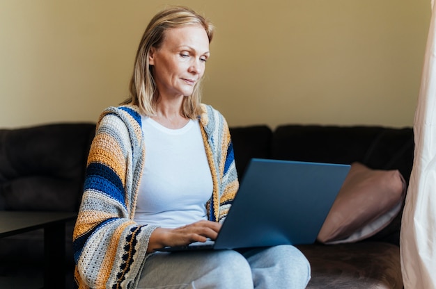 Mulher em casa durante quarentena com laptop