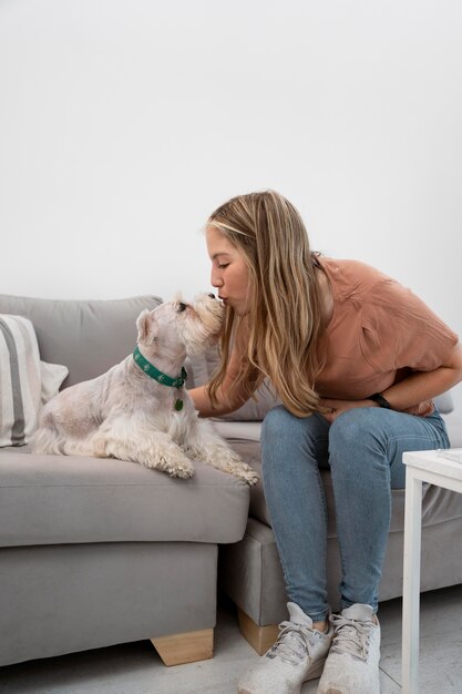 Mulher em cena completa beijando cachorro