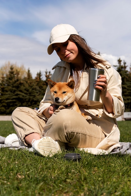 Mulher em cena completa segurando um cachorro fofo