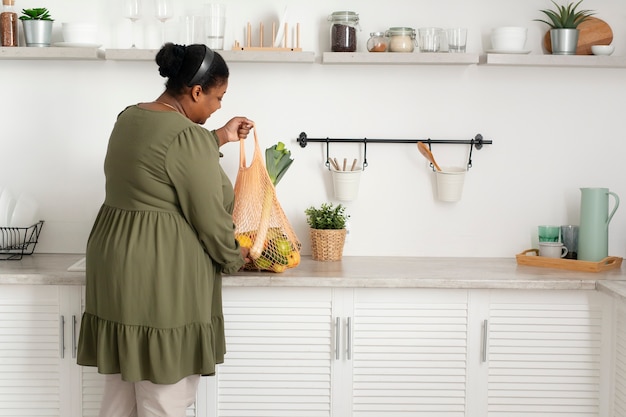 Mulher em cena completa segurando um saco reciclável