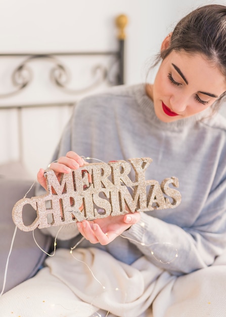 Mulher, em, cinzento, segurando, madeira, feliz natal, inscrição