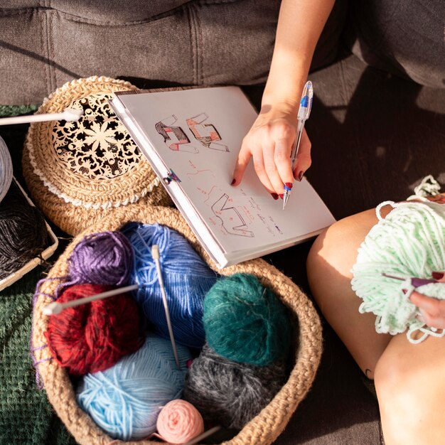 Mulher em close-up fazendo crochê de acordo com a modelo