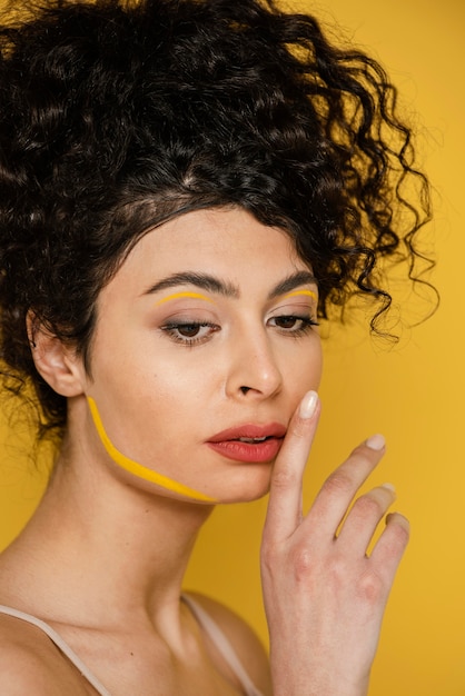 Mulher em close-up posando com fundo amarelo