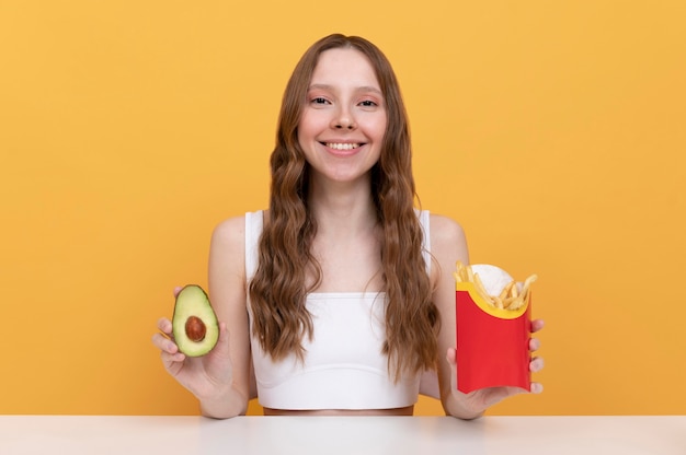 Mulher em dose média com abacate e batatas fritas