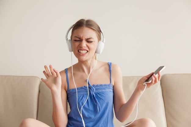 Mulher em fones de ouvido, ouvindo música do celular