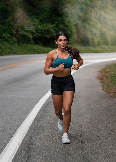 Foto grátis mulher em forma de tiro completo correndo ao ar livre