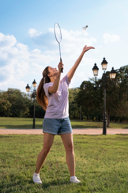 Mulher em forma de tiro completo jogando badminton