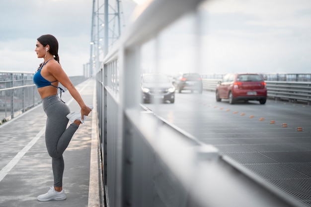 Foto grátis mulher em forma de tiro completo se alongando ao ar livre