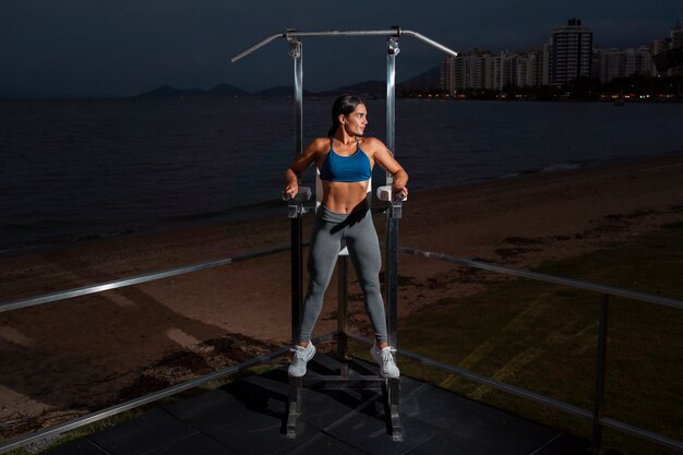 Mulher em forma de tiro completo treinando com máquina