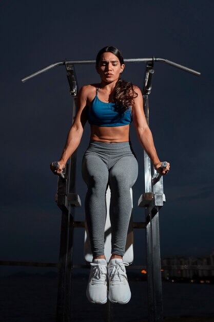 Mulher em forma de tiro completo treinando com máquina