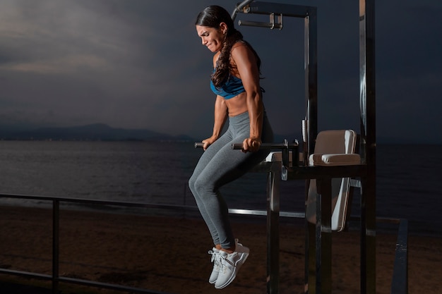 Mulher em forma de tiro completo treinando com máquina