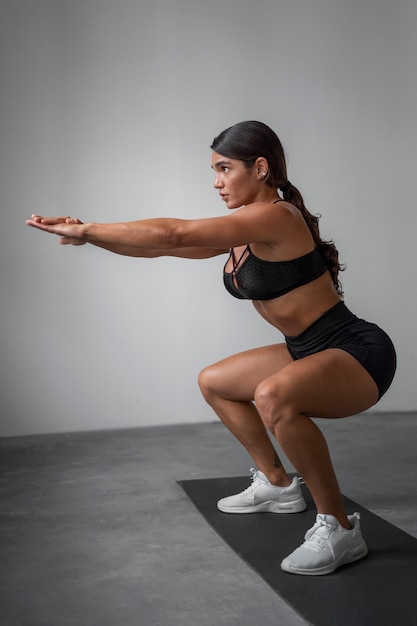 Foto grátis mulher em forma de tiro completo treinando dentro de casa