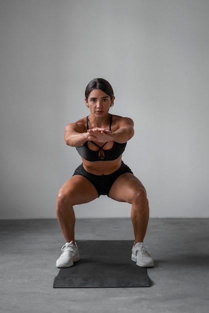 Mulher em forma de tiro completo treinando dentro de casa