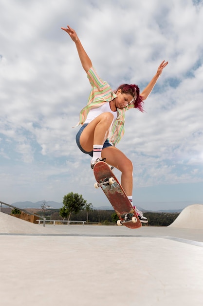 Mulher em foto completa pulando com skate