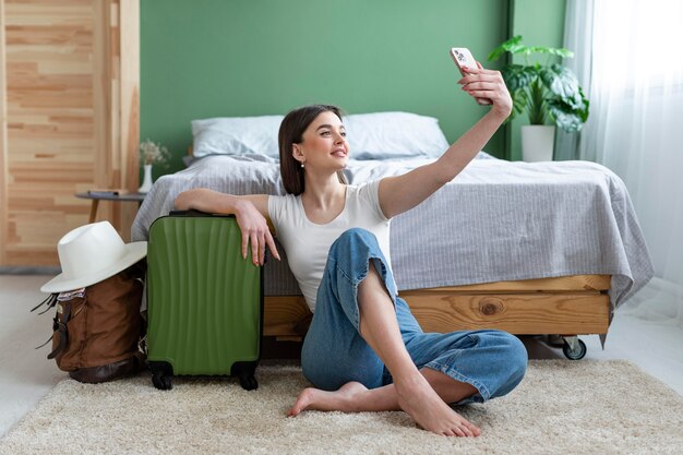 Mulher em foto completa tirando selfie em casa