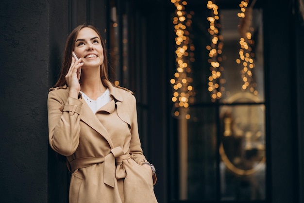 Foto grátis mulher em frente ao café usando o telefone