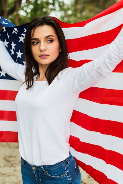 Mulher, em, natureza, segurando, bandeira americana