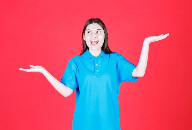 Mulher em pé de camisa azul.