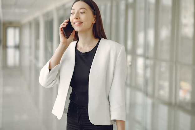 Mulher em pé no escritório com um telefone