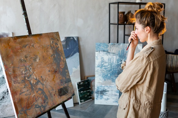 Foto grátis mulher em plano médio olhando para uma pintura