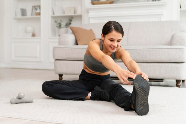 Mulher em roupas esportivas se exercitando em casa