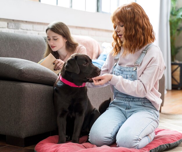 Mulher em tiro completo alimentando cachorro