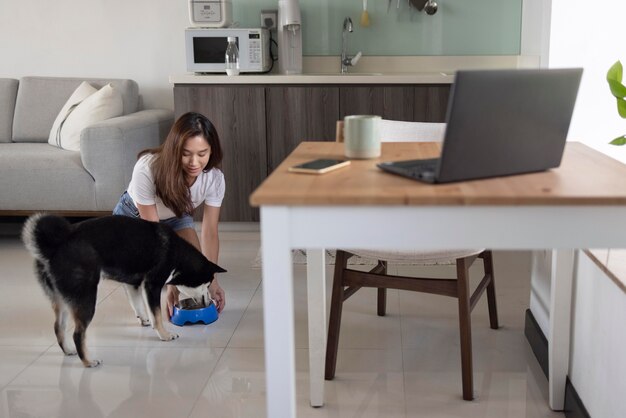 Mulher em tiro completo alimentando cachorro