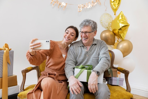 Mulher em tiro médio e homem sênior tirando uma selfie