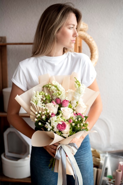 Mulher em tiro médio segurando flores