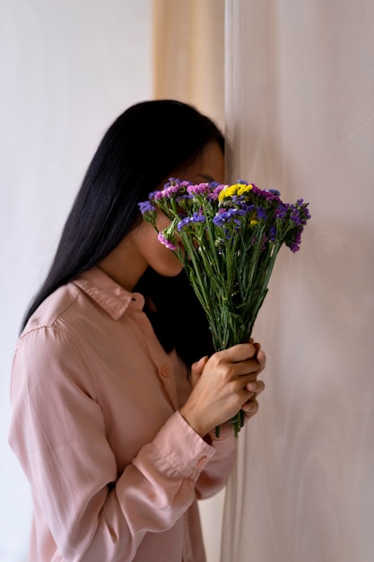 Mulher em tiro médio segurando flores