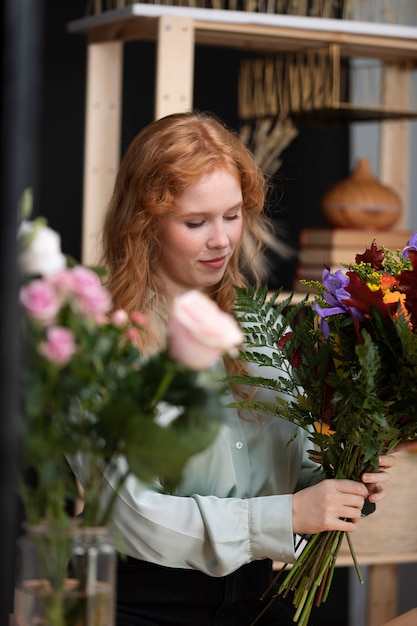 Foto grátis mulher em tiro médio segurando flores