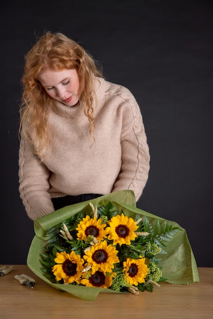 Mulher em tiro médio segurando um buquê de flores