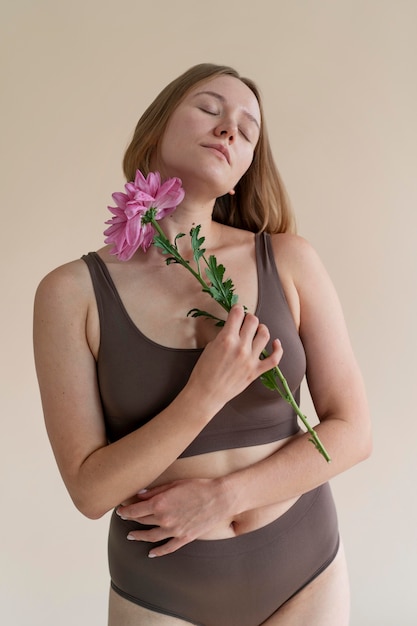 Mulher em tiro médio segurando uma flor