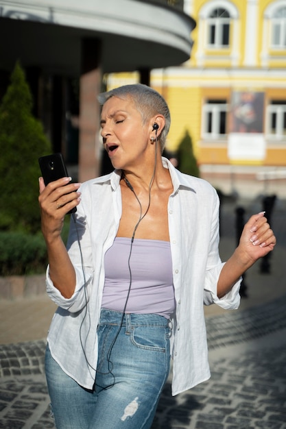 Foto grátis mulher em tiro médio usando fones de ouvido