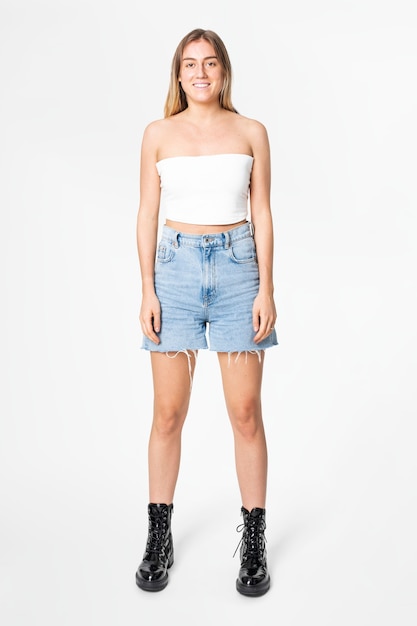 Mulher em top branco cai-cai e saia jeans, moda casual de corpo inteiro