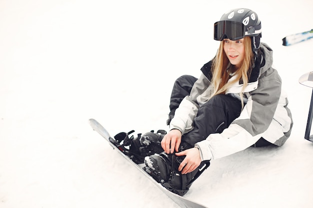 Mulher em traje de snowboard. desportista em uma montanha com uma prancha de snowboard nas mãos no horizonte. conceito em esportes