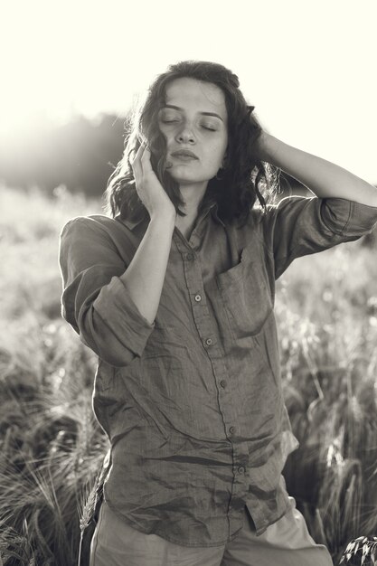 Mulher em um campo de verão. Morena com uma camisa verde.