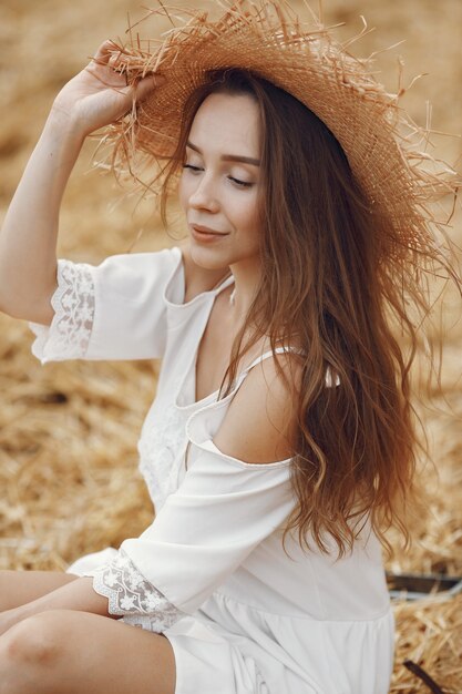 Mulher em um campo de verão. Senhora de vestido branco.