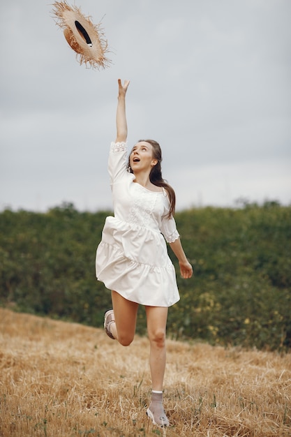 Mulher em um campo de verão. Senhora de vestido branco.