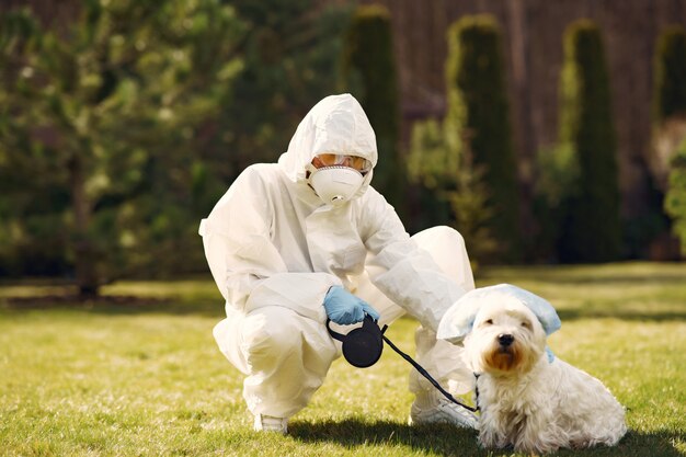 Mulher em um traje de proteção andando com um cachorro