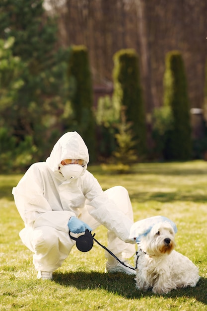 Mulher em um traje de proteção andando com um cachorro