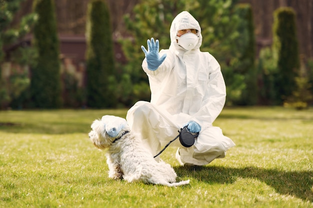 Mulher em um traje de proteção andando com um cachorro