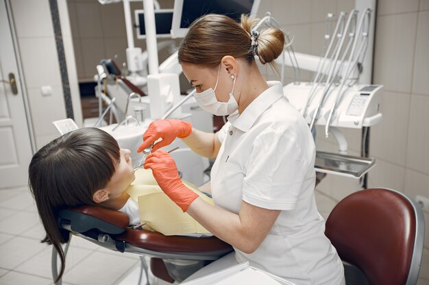 Mulher em uma cadeira de dentista. A menina é examinada por um dentista. A beleza trata os dentes