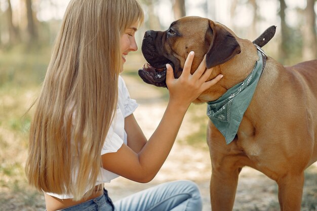 mulher em uma floresta de verão brincando com cachorro