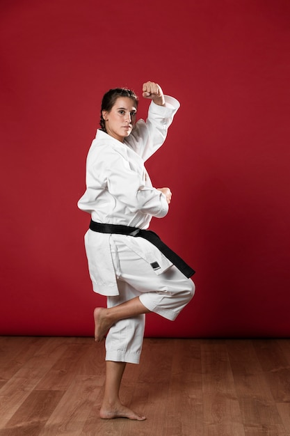 Foto grátis mulher em uniforme de artes marciais, exercitando karatê