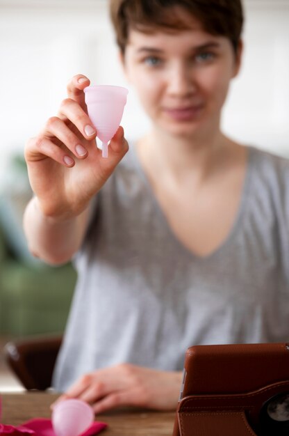 Mulher embaçada de tiro médio com copo menstrual