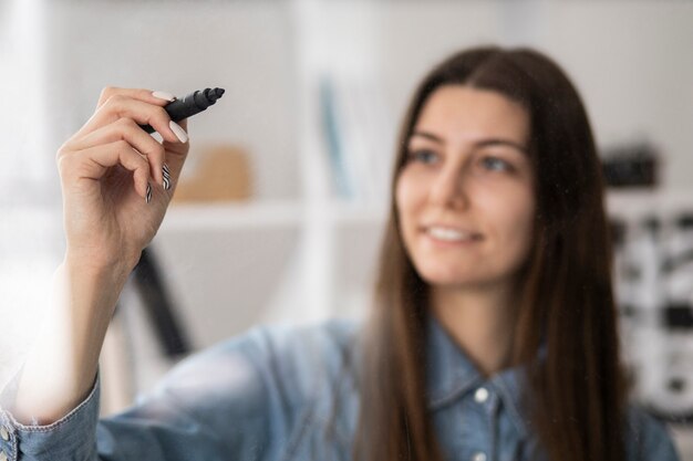 Mulher embaçada sorridente de tiro médio segurando o marcador