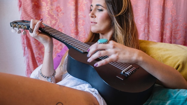 Mulher encantadora brincando ukulele