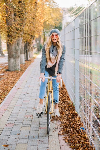 Mulher encantadora em bicicleta perto da cerca