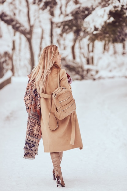 Mulher encantadora está andando na rua no inverno